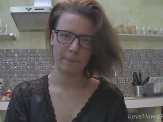 Solo young woman with glasses chatting in the kitchen